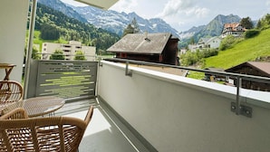 A balcony with a view of a mountain landscape, a table with chairs, and a railing. - Sunnmatt West Wohnung 933 Appartement/Fewo 5-Bettwohnung by Interhome (Engelberg)