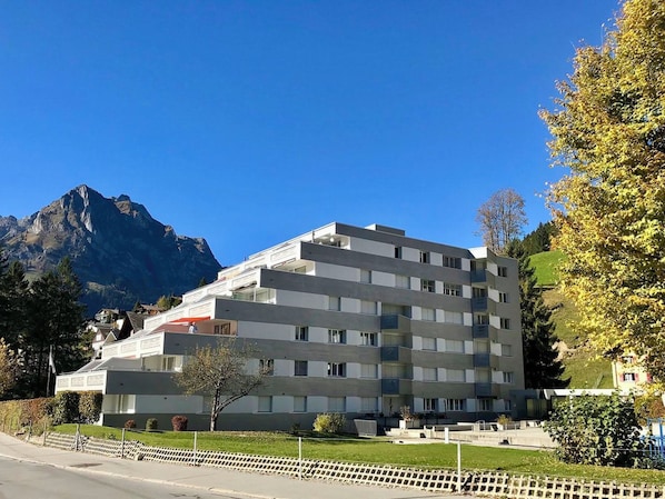 Een hotel met meerdere verdiepingen, modern van ontwerp, met balkons en uitzicht op een berg.