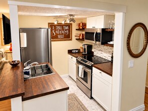 A compact kitchen with a built-in oven, microwave, and a coffee maker.