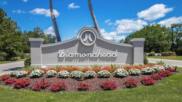Un panneau portant l’inscription « Diamondhead », entouré d’un parterre fleuri aux couleurs variées.