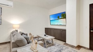 A living room with a sofa, a coffee table, a TV, and a cabinet. - Tormenta 101 3BR Ground Floor San Jose del Cabo (San José del Cabo)