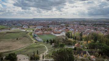 Un paisaje urbano con edificios residenciales, un campo deportivo y una zona de parque.