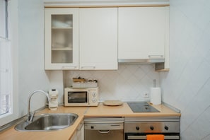 A kitchen with a sink, a microwave, a toaster, and a dishwasher.