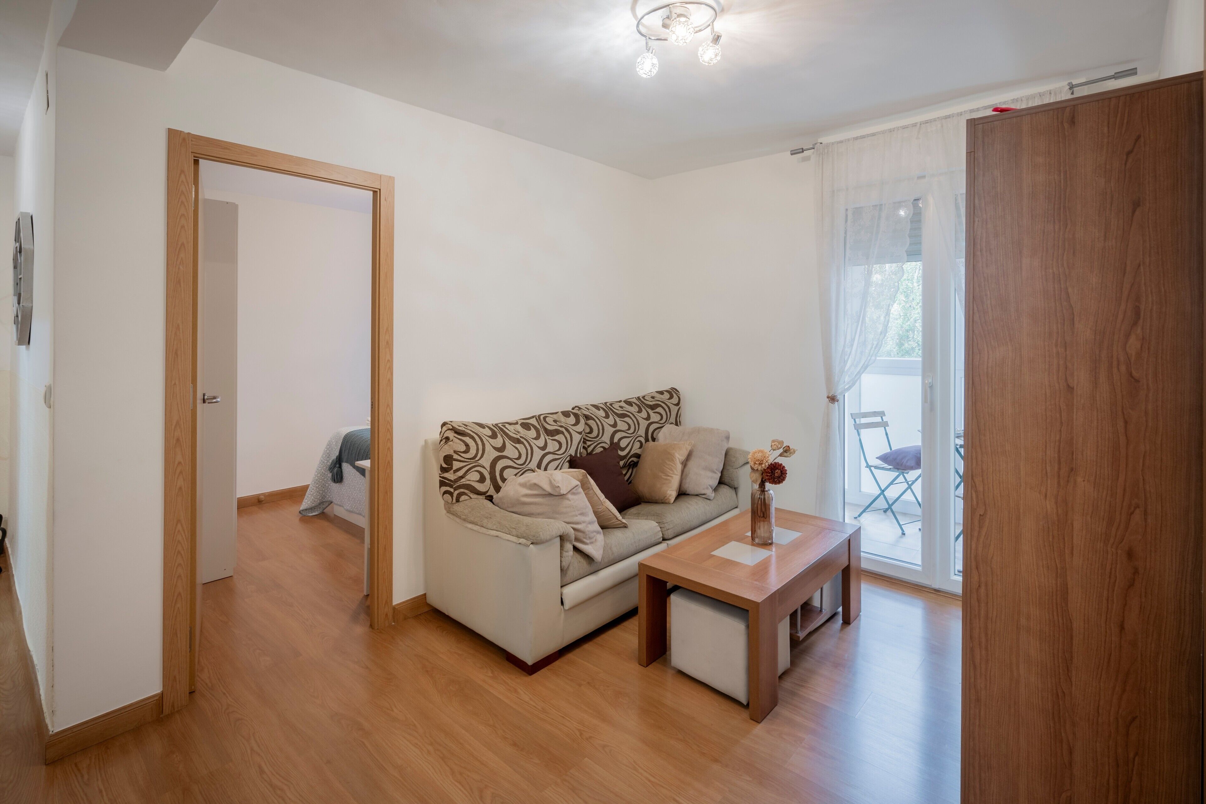 A living room with a sofa, a coffee table, and a wooden door.