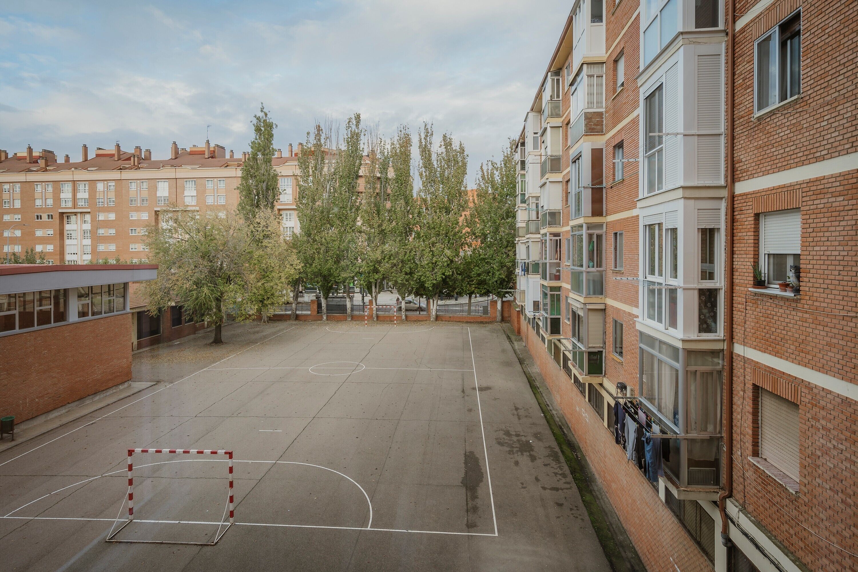 Un terrain de basket en plein air, entouré d’immeubles d’habitation.
