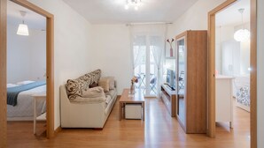 A modern living room with a sofa, a coffee table, and a TV.