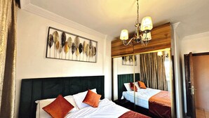 Ett hotellrum med en stor säng, en spegel och en kristallkrona.