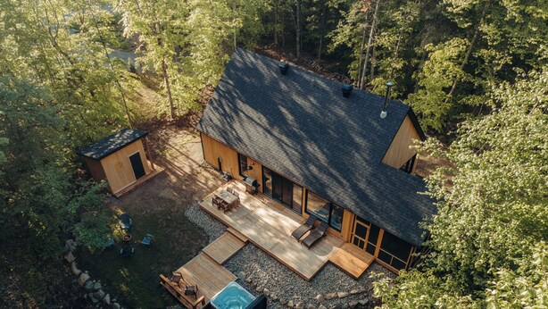 A modern house with a deck, hot tub, and a small shed. - Cabine Origine  (Lac-Supérieur)