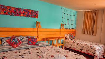 Une chambre avec deux lits, une tête de lit en bois, une décoration murale, un luminaire suspendu et une fenêtre avec des rideaux.