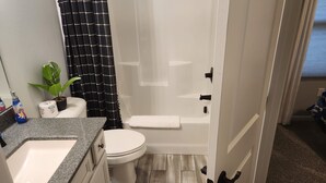 A bathroom with a toilet, sink, and shower area. - 3-bedroom house located near Camdenton. Nestled In Old Kinderhook community.  (Camdenton)
