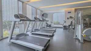 Ein Fitnessstudio mit Laufbändern, Fahrrädern und Krafttrainingsgeräten.