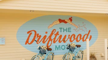 Un edificio con un mural de dos bicicletas y el texto 'The Driftwood Motel'.
