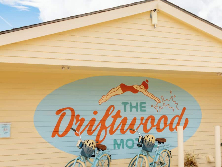 Un edificio con un mural de dos bicicletas y el texto 'The Driftwood Motel'.