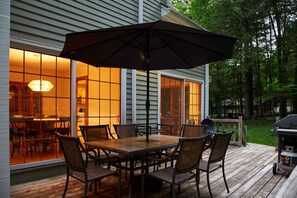 An outdoor deck with a wooden table and chairs, a large umbrella, and a grill. - Perfect Nature Haven In Great Barrington (Great Barrington)