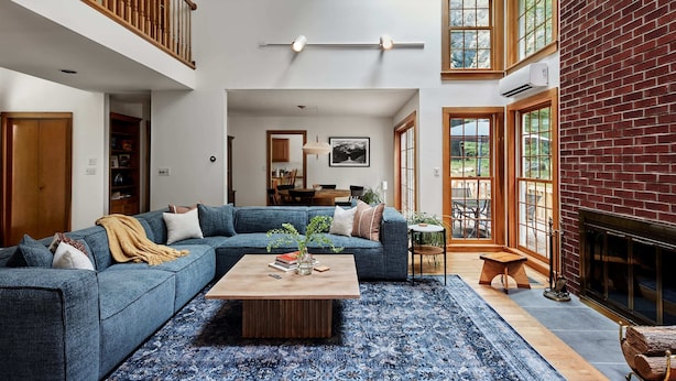 A spacious living room with a blue sofa, a wooden coffee table, and a fireplace. - Perfect Nature Haven In Great Barrington (Great Barrington)