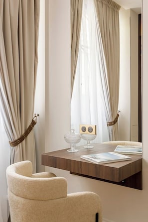 Una habitación con un escritorio de madera, una silla y un espejo.