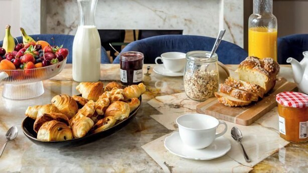 A breakfast setting with croissants, fruit, milk, and juice on a marble table. - Merveil - Signature Suite -Tour Eiffel- Grenelle I (Paris)