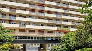A multi-story residential building with balconies, a swimming pool, and a garden area. - Merveil - Signature Suite -Tour Eiffel- Grenelle I (Paris)
