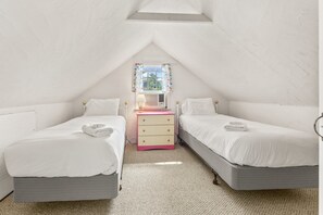 A bedroom with two beds, a dresser, and a window with curtains. - Cape Cod Cottage Near Beaches & Bike Trail (Harwich)
