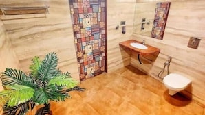 A bathroom with a tiled floor, a sink, a toilet, and a decorative panel with various patterns.