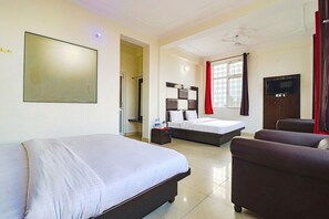 A hotel room with two beds, a TV, a sofa, and a large window. -  Hotel Binog Breeze (Dhanaulti)