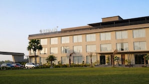 Ein modernes Hotel mit flachem Dach, zahlreichen Fenstern und einem Schild mit der Aufschrift 'RIVAAH'.