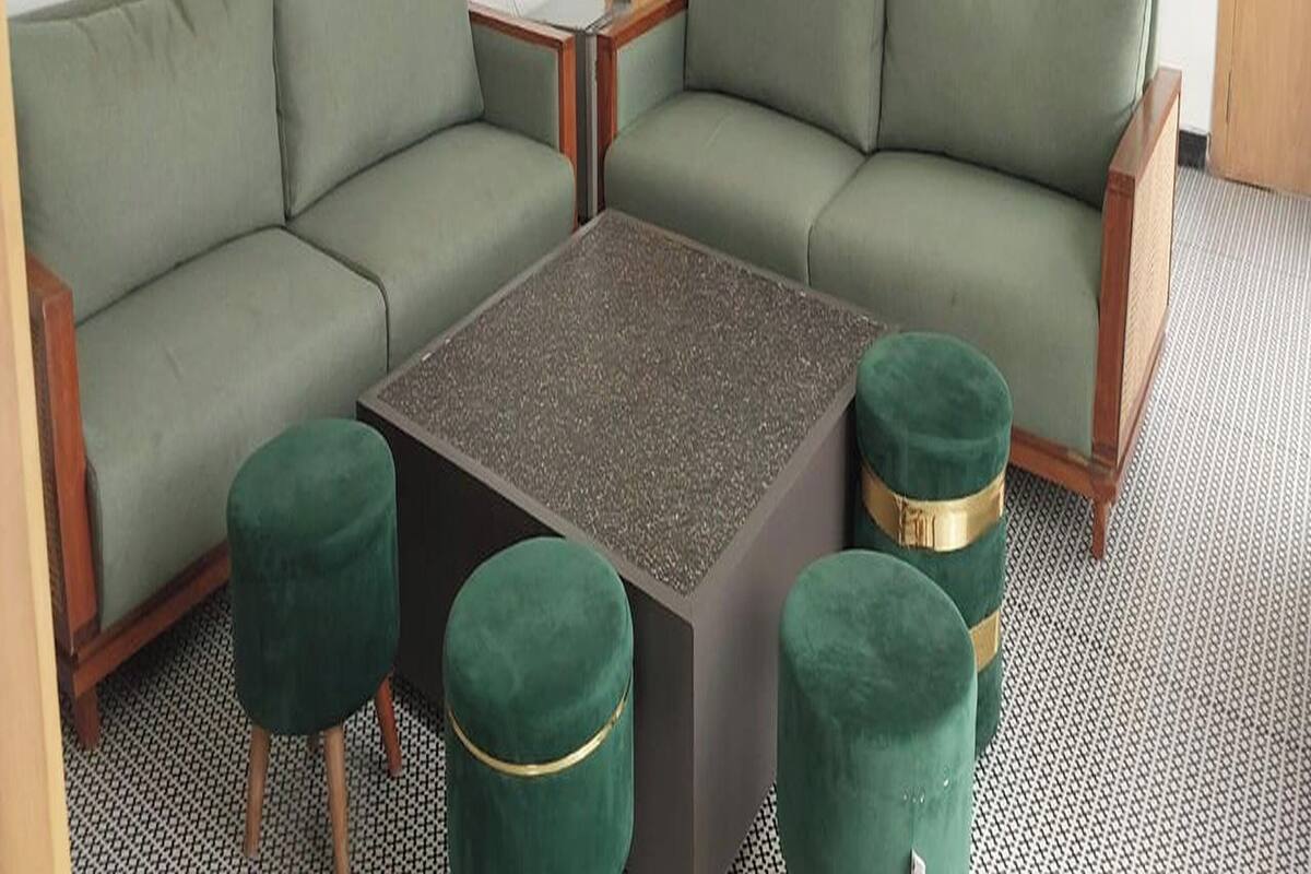 Una sala moderna con un sofá modular, una mesa de centro y otomanas a juego.