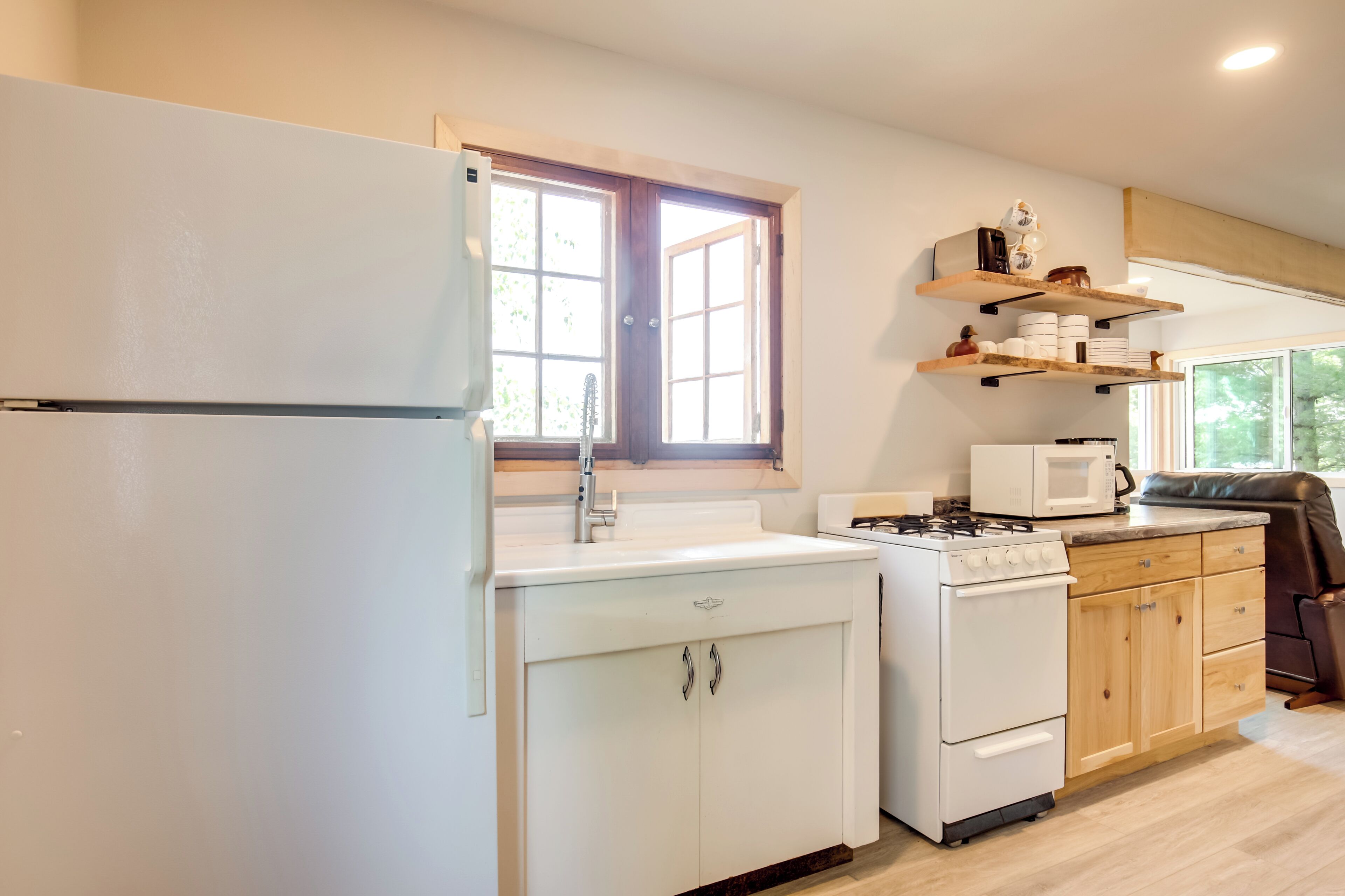 A kitchen with a refrigerator, stove, microwave, and wooden cabinets.
