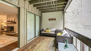 A cozy balcony with wicker furniture, a green lantern, and a sign that says "EXPLORE". - Sapphire Valley Condo w/ Pool & Lake Beach Access! (Sapphire)