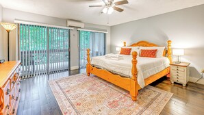 A bedroom with a wooden bed, a ceiling fan, a nightstand, and a view through a sliding glass door to an outdoor area. - Sapphire Valley Condo w/ Pool & Lake Beach Access! (Sapphire)