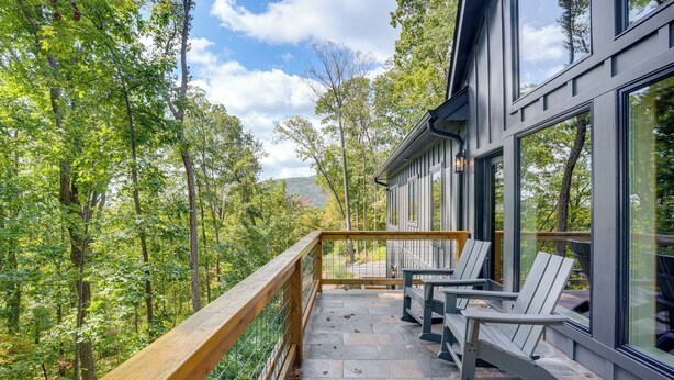 A balcony with a wooden railing overlooking a forested area. - Modern Nellysford Getaway w/ View: Deck & Fire Pit (Nellysford)
