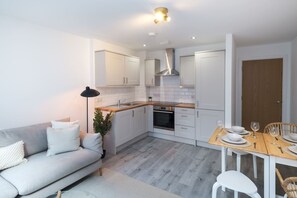Cozy kitchen and dining area with oven, stainless steel range hood, and seating for four.
