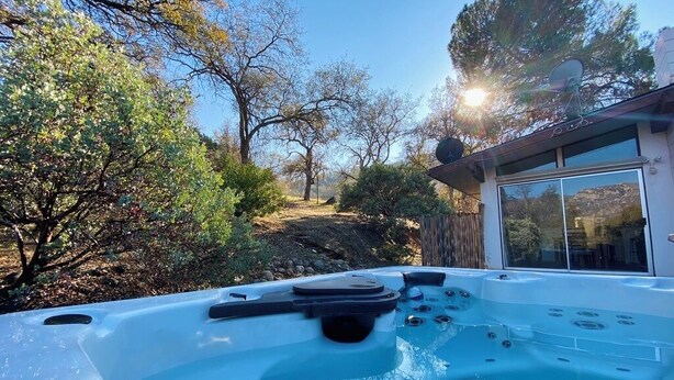 A hot tub in a backyard with a view of trees and a house. - Spa, 5 minutes from Sequoia National Park. Spacious, convenient and private. (Three Rivers)