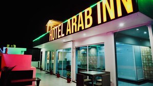 A hotel exterior with a prominent sign reading "HOTEL ARAB INN" and a glass facade. - HOTEL ARAB INN (Mohali)