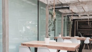 A modern meeting room with glass walls, wooden tables, and white chairs. - HOTEL ARAB INN (Mohali)