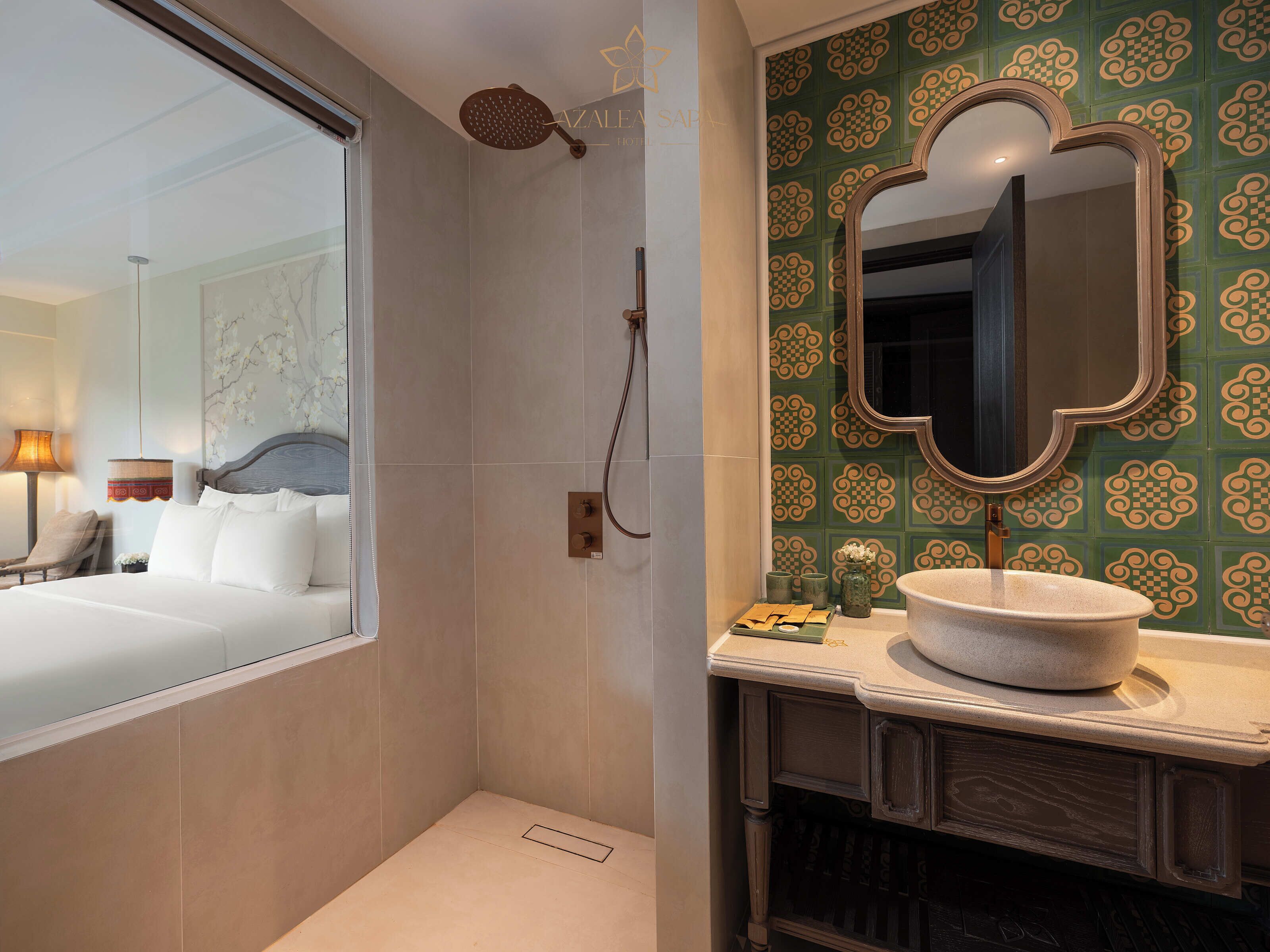 Un baño de hotel con ducha, lavamanos y espejo.
