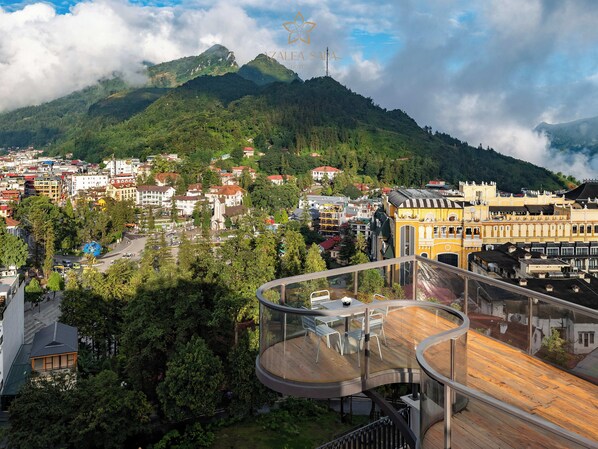 A hotel with a modern design, featuring a curved balcony with outdoor seating.