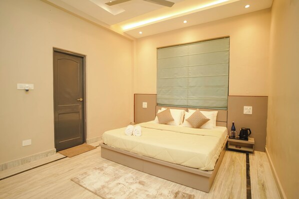 A modern bedroom with a large bed, bedside tables, and a nightstand.