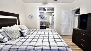 Un dormitorio con una cama grande, televisión y armario.