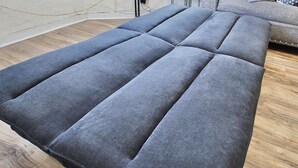 Un sofá modular con diseño capitonado y suelo de madera.