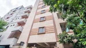 A multi-story hotel with a modern design, featuring balconies and a sign indicating it is the "Hotel Avasa." - iROOMZ Eco Avasya Residency (Hyderabad)