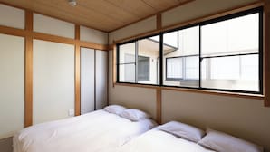 Una habitación con cama, ventana y paneles de madera.