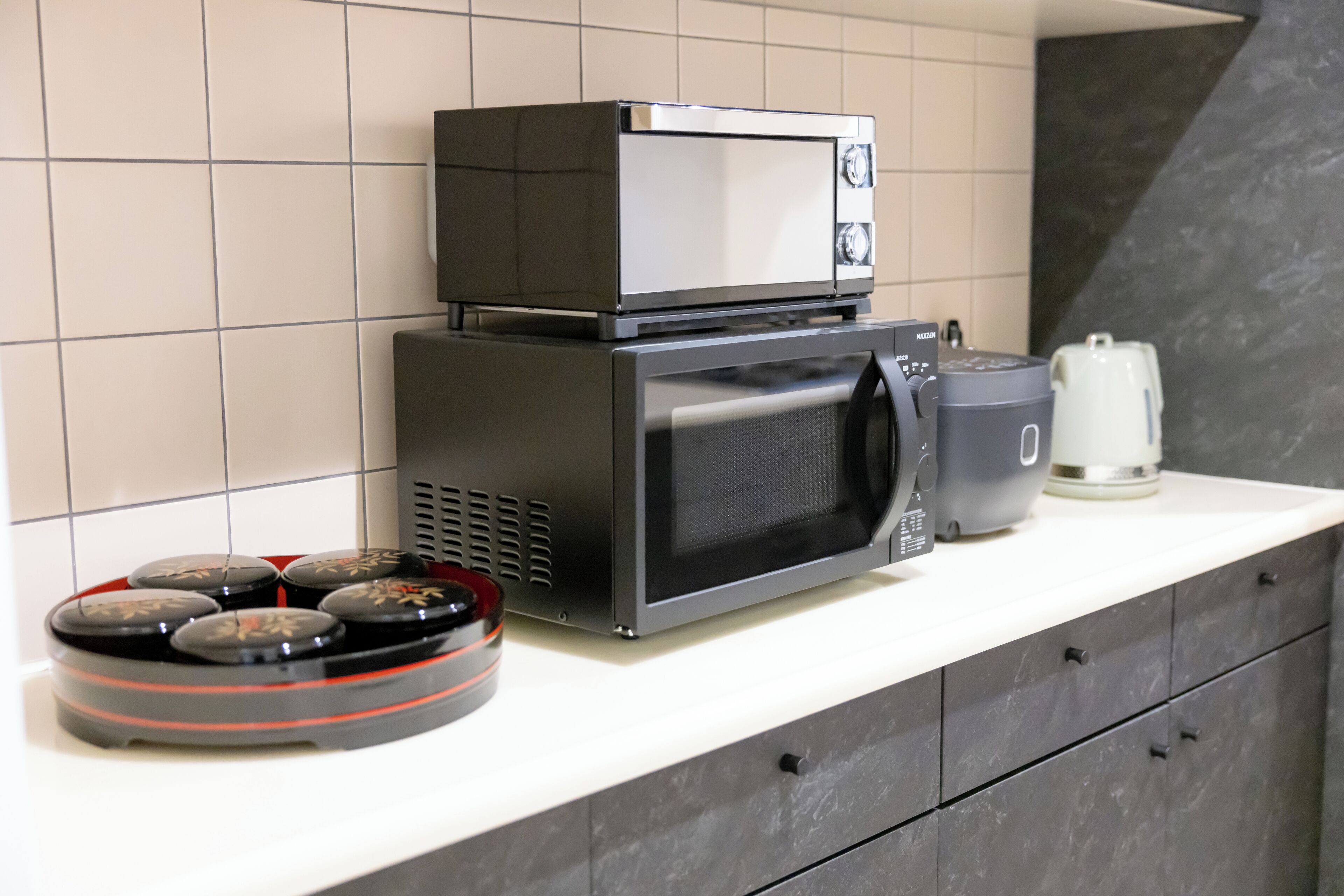 Eine Küche mit Mikrowelle, Kaffeemaschine und kleinem Herd.
