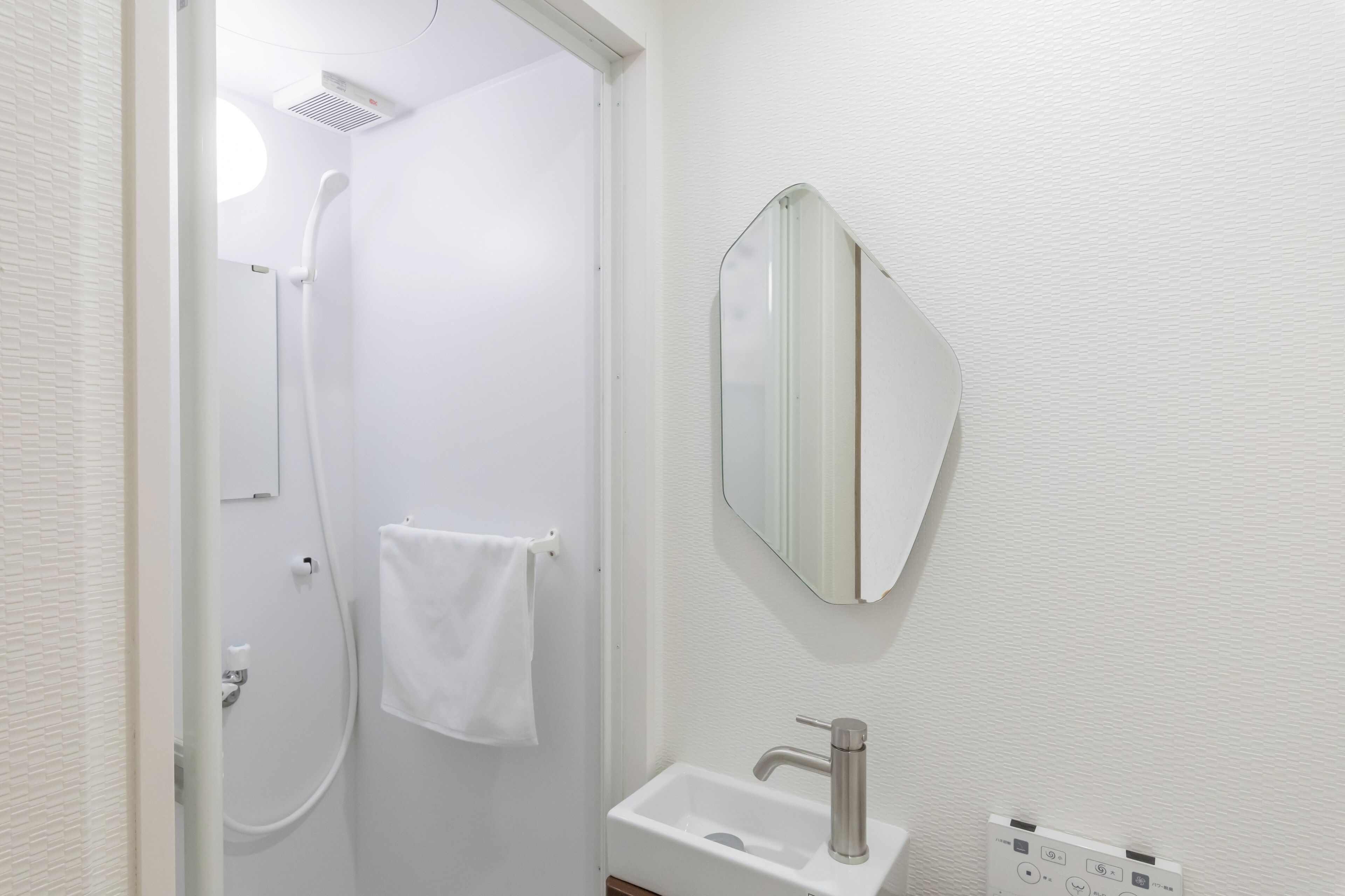 Un bagno con doccia, lavandino e specchio.