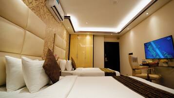 A hotel room with two beds, a television, a desk, and a wardrobe.