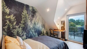 Un dormitorio con una cama grande, un escritorio y vistas al exterior.