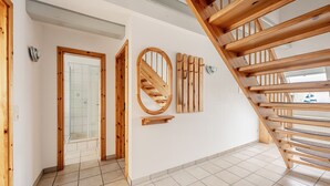 Eine Holztreppe mit einer Glastür zu einem Badezimmer.
