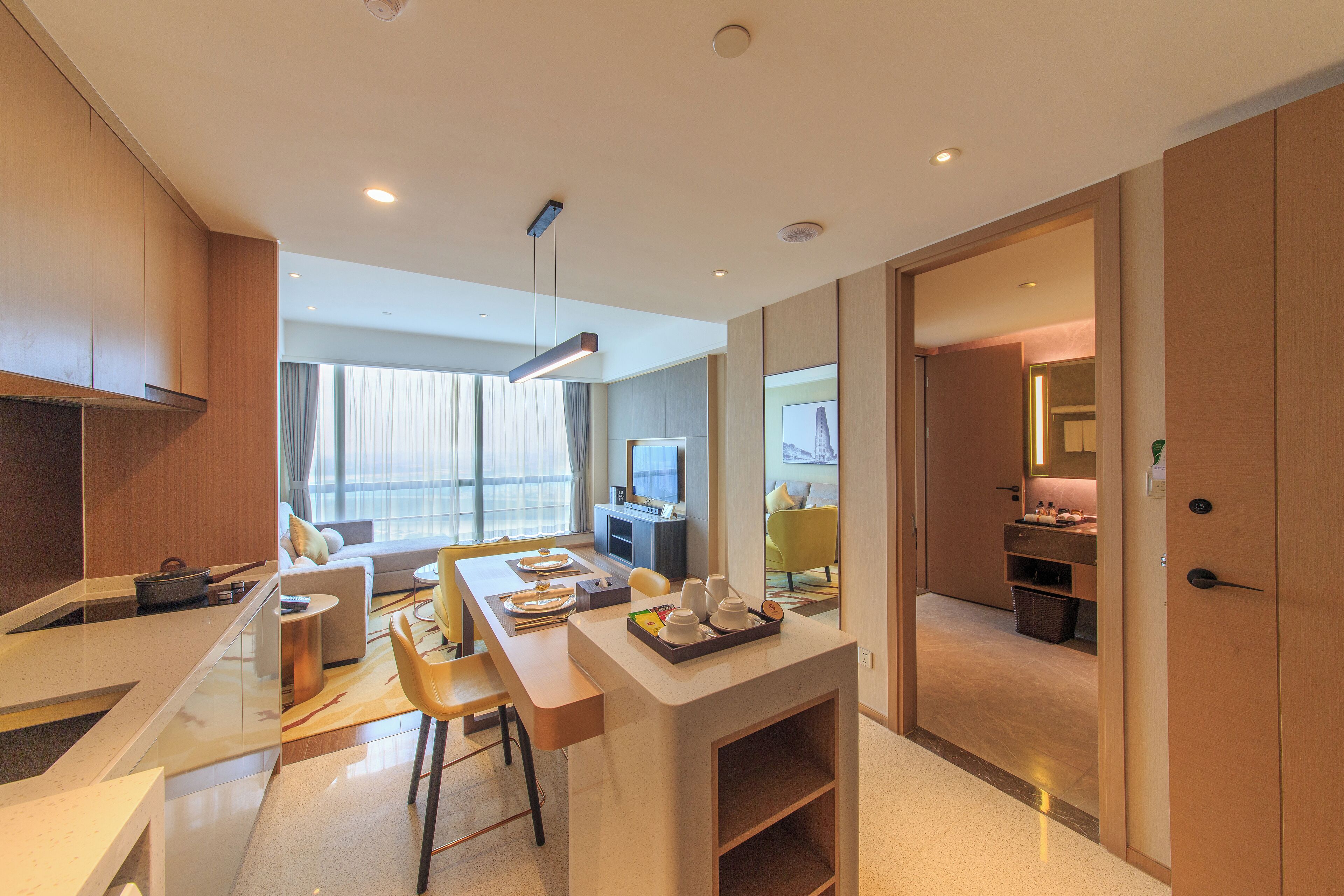 A modern kitchen with a dining area, a small island, and a view of the living room.