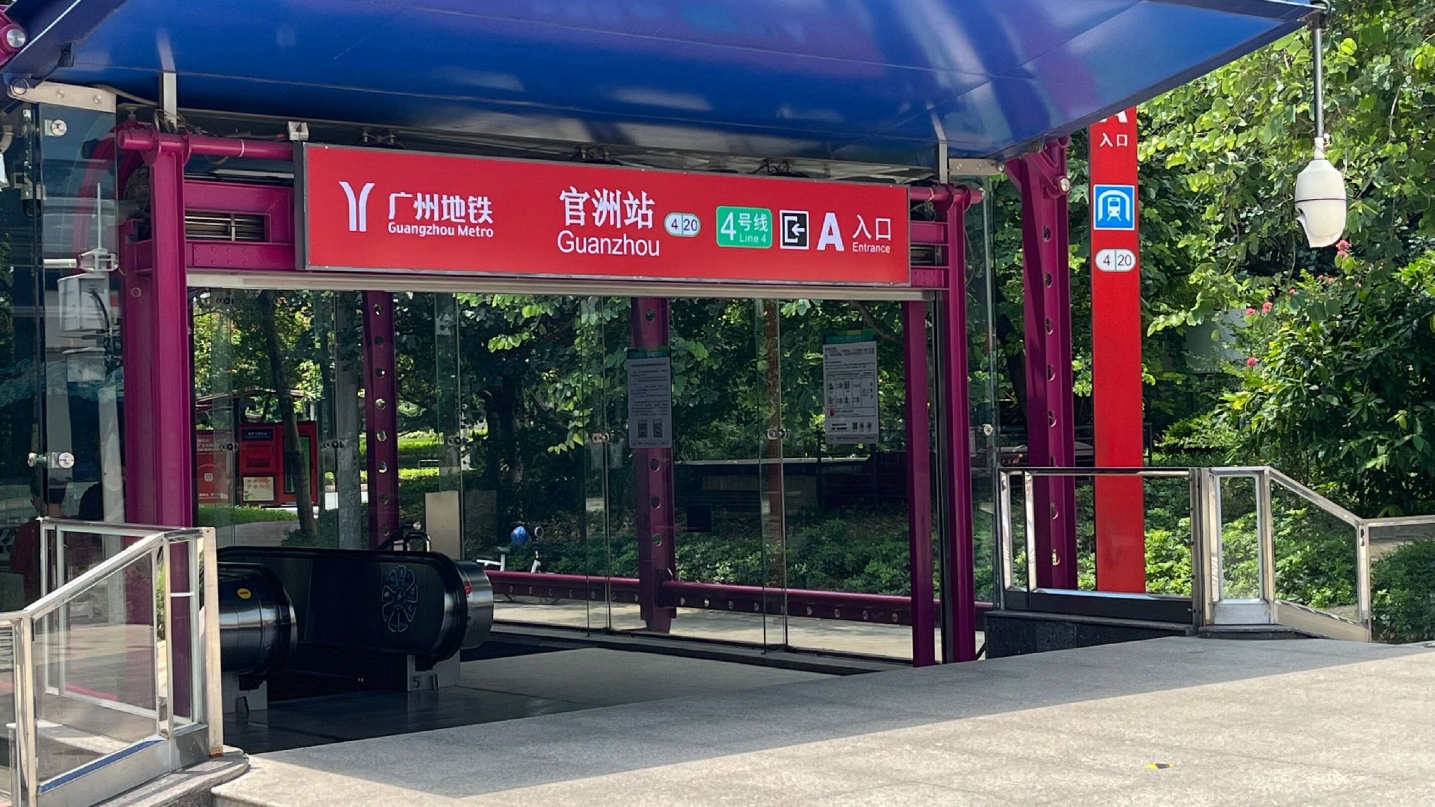 A Guangzhou Metro station entrance with a red shelter, glass barriers, and a sign indicating Line 4.