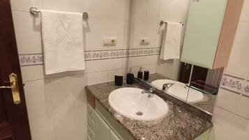 Une salle de bain avec deux lavabos, un grand miroir et un porte-serviettes.